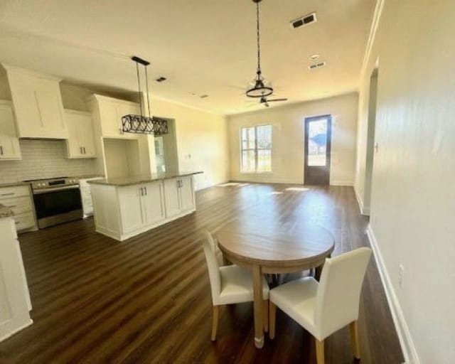 dining room featuring dark hardwood / wood-style floors, ceiling fan, and ornamental molding