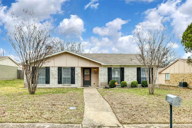 ranch-style home with a front lawn and central air condition unit