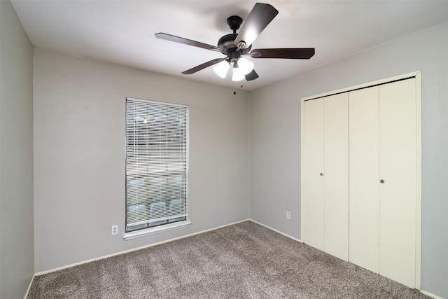 unfurnished bedroom with carpet flooring, ceiling fan, and a closet