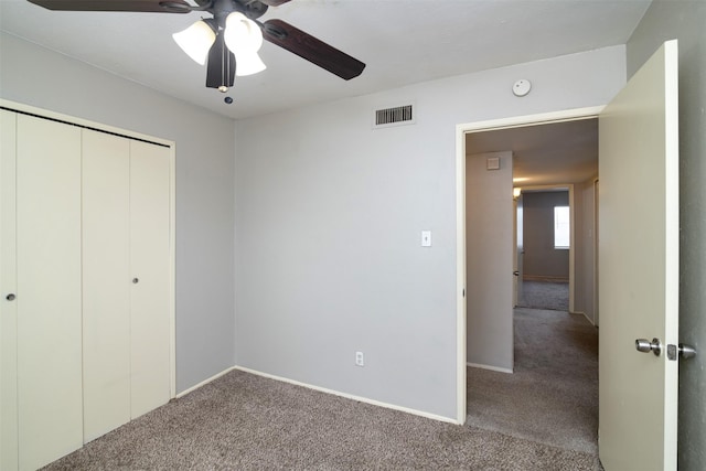 unfurnished bedroom with carpet flooring, ceiling fan, and a closet