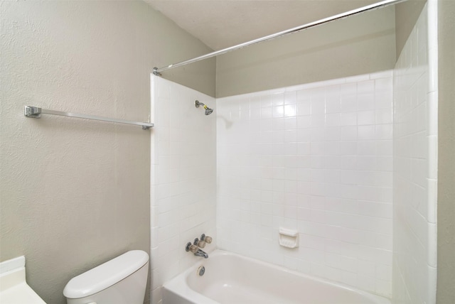 bathroom with toilet and tiled shower / bath