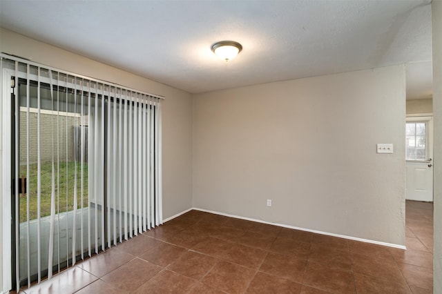 unfurnished room featuring dark tile patterned floors