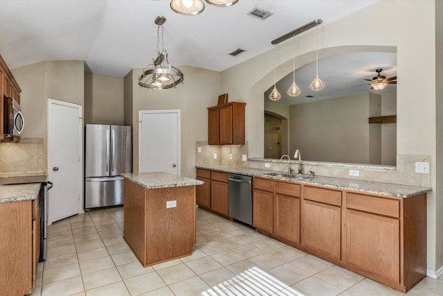 kitchen featuring ceiling fan, sink, a center island, tasteful backsplash, and appliances with stainless steel finishes