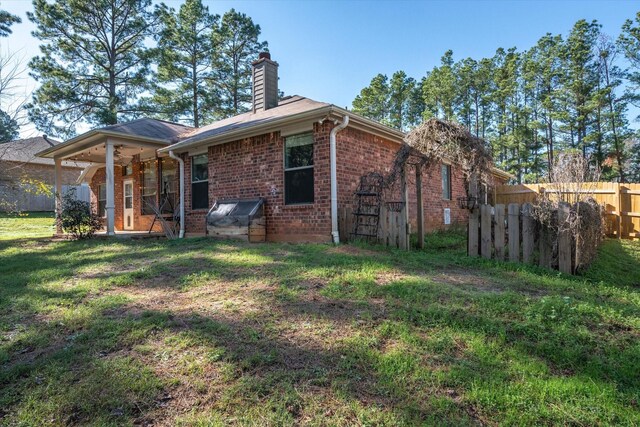 rear view of house featuring a lawn