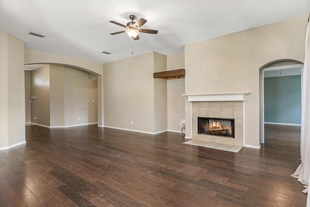 unfurnished living room with dark hardwood / wood-style floors, ceiling fan, and a tile fireplace