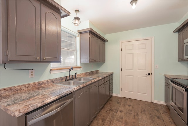 kitchen featuring dark wood-type flooring, stainless steel appliances, and sink