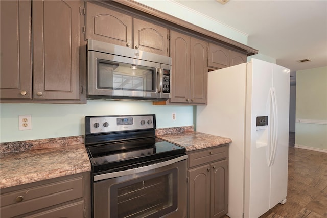 kitchen featuring stainless steel appliances and dark hardwood / wood-style floors