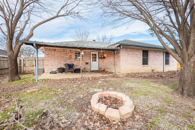 rear view of property featuring a patio area and a fire pit