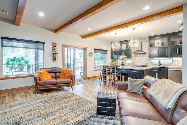 living room with sink, beam ceiling, and light hardwood / wood-style floors