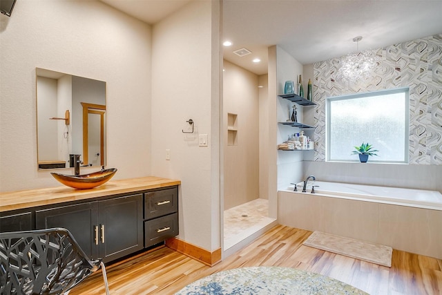 bathroom featuring vanity, hardwood / wood-style flooring, and separate shower and tub