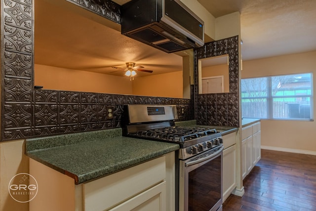 kitchen with dark hardwood / wood-style flooring, stainless steel gas range, ceiling fan, dark stone countertops, and white cabinets