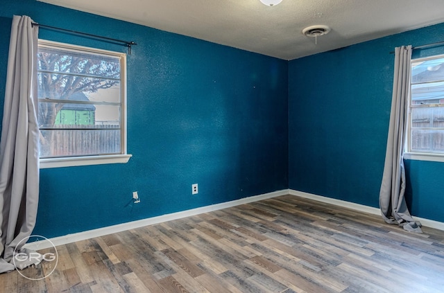 spare room with wood-type flooring and a textured ceiling