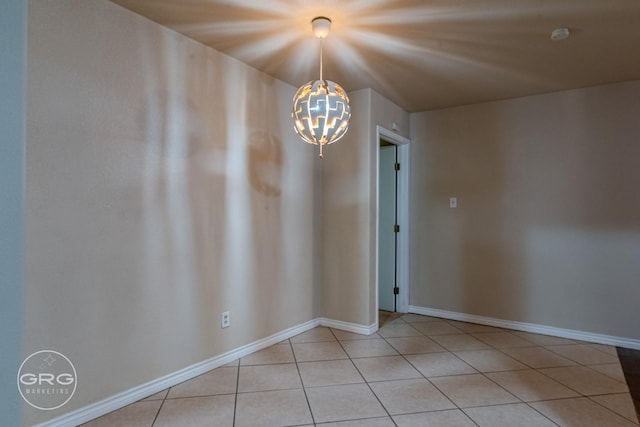 empty room featuring light tile patterned floors and a notable chandelier