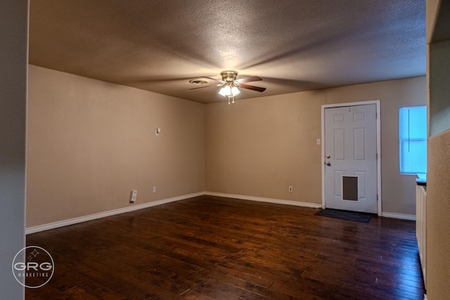 unfurnished room featuring ceiling fan, dark hardwood / wood-style flooring, and a textured ceiling