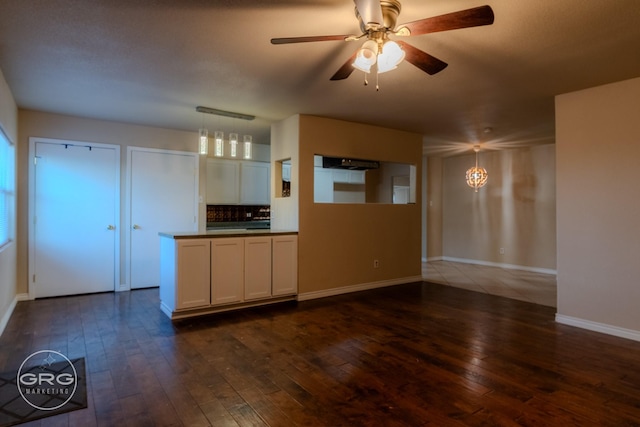 kitchen featuring backsplash, ceiling fan, pendant lighting, white cabinets, and dark hardwood / wood-style floors