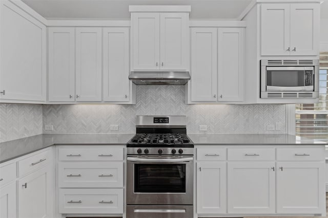 kitchen featuring decorative backsplash, appliances with stainless steel finishes, and white cabinetry