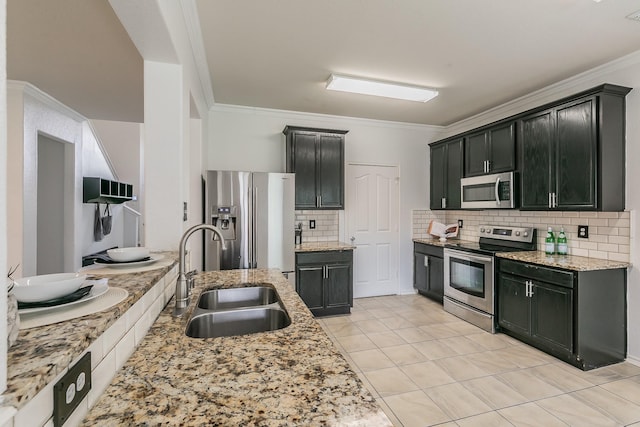 kitchen featuring decorative backsplash, light stone counters, ornamental molding, stainless steel appliances, and sink