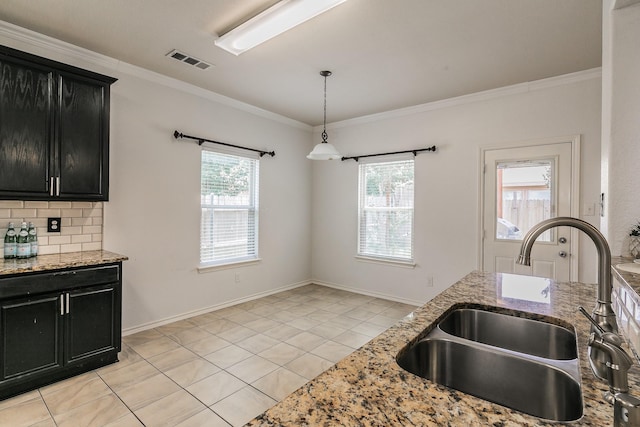 kitchen with light stone countertops, decorative backsplash, ornamental molding, sink, and light tile patterned floors