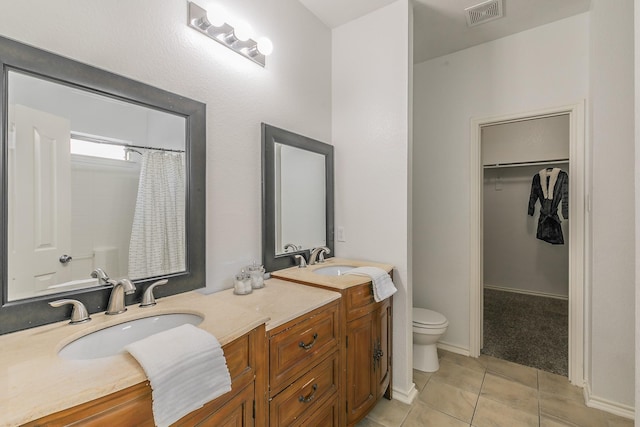 bathroom with tile patterned flooring, vanity, and toilet