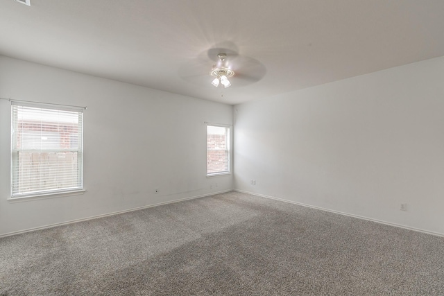 carpeted spare room featuring ceiling fan