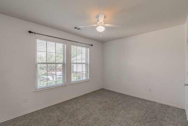 empty room featuring dark colored carpet and ceiling fan