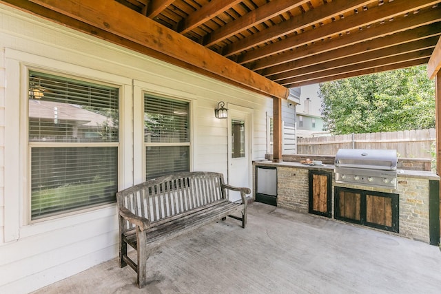 view of patio with area for grilling, exterior kitchen, and a wall unit AC