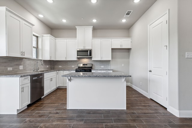 kitchen with white cabinets, a kitchen island, and appliances with stainless steel finishes