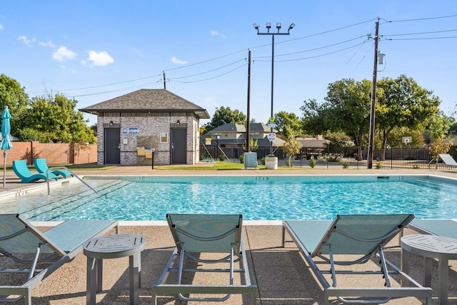 view of pool featuring a patio area, an outbuilding, and cooling unit