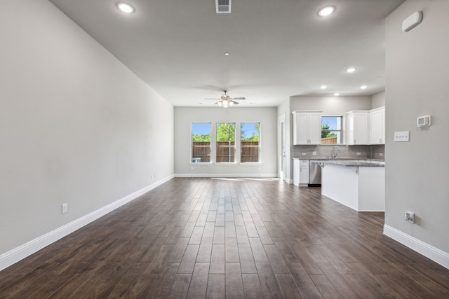 unfurnished living room featuring ceiling fan and sink