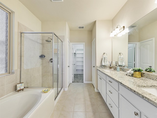 bathroom with tile patterned flooring, vanity, and plus walk in shower