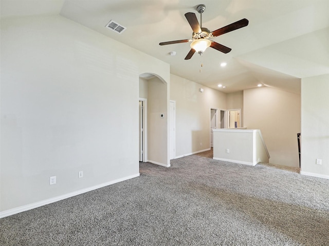 empty room with dark colored carpet, ceiling fan, and lofted ceiling