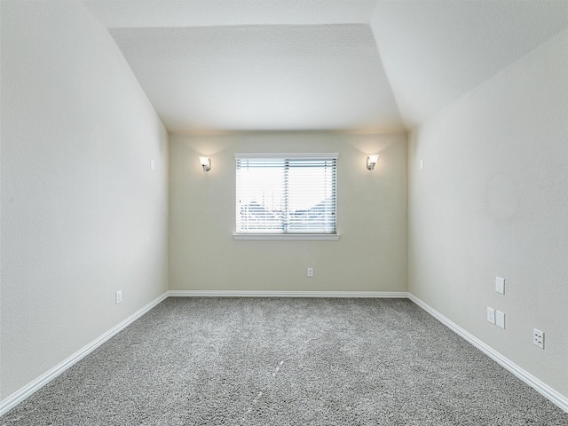 unfurnished room featuring carpet and lofted ceiling