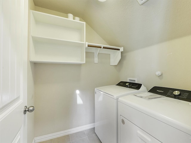 laundry area with washing machine and dryer, light tile patterned floors, and a textured ceiling