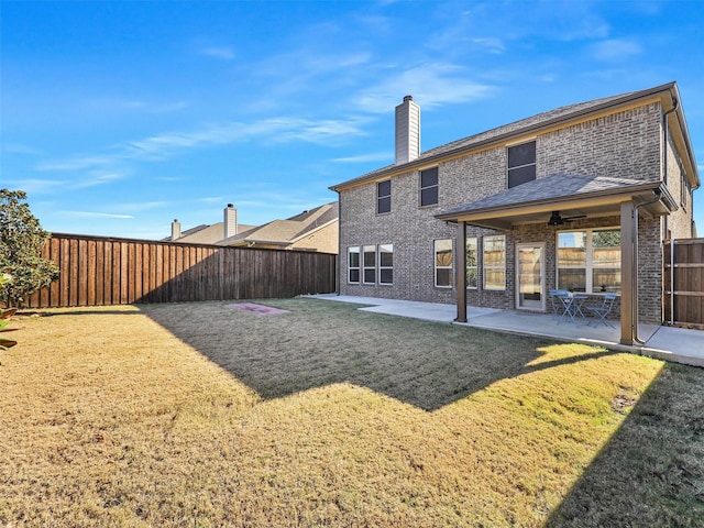 back of house featuring ceiling fan, a yard, and a patio