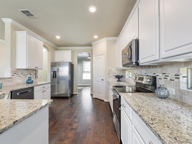 kitchen with light stone countertops, tasteful backsplash, stainless steel appliances, white cabinets, and dark hardwood / wood-style floors