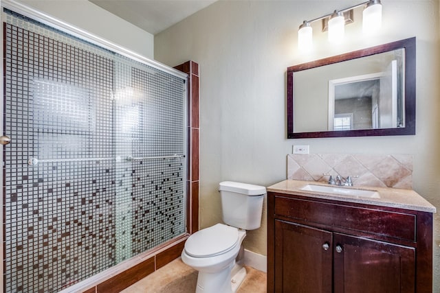 bathroom featuring tile patterned flooring, vanity, toilet, and a shower with shower door