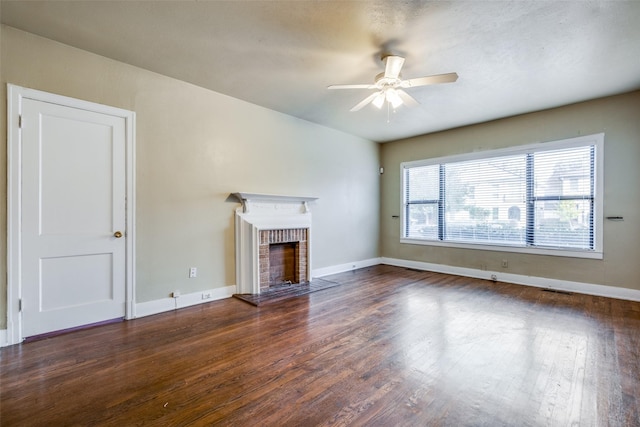 unfurnished living room featuring a fireplace, dark hardwood / wood-style flooring, and ceiling fan