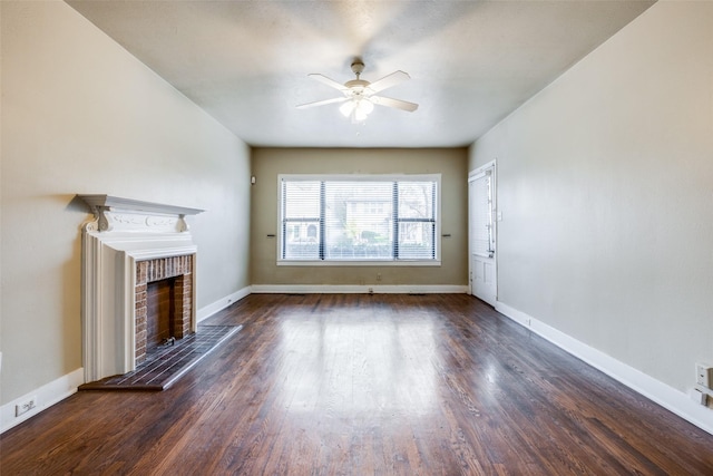 unfurnished living room with ceiling fan, dark hardwood / wood-style floors, and a brick fireplace