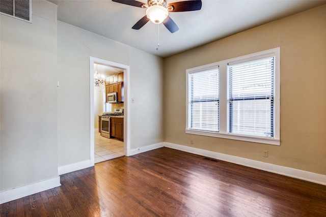 spare room featuring light hardwood / wood-style flooring and ceiling fan with notable chandelier