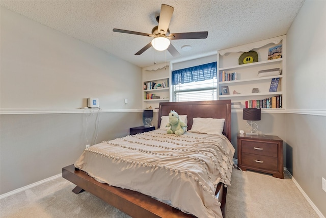 bedroom with ceiling fan, light carpet, and a textured ceiling