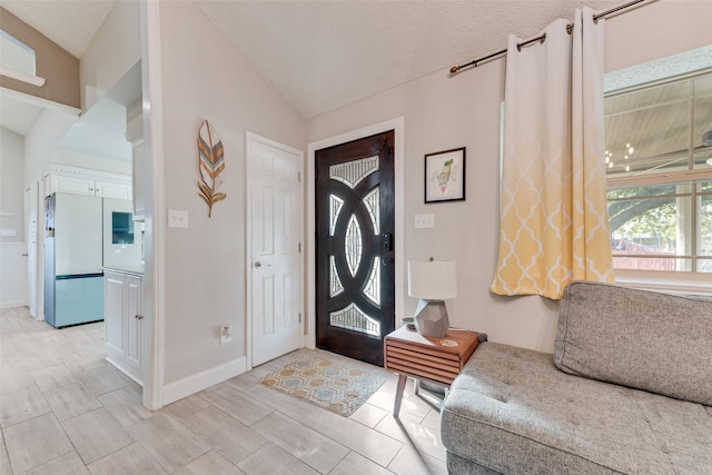 entrance foyer featuring a textured ceiling and vaulted ceiling