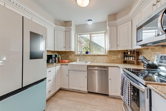 kitchen with white cabinetry, sink, backsplash, and appliances with stainless steel finishes