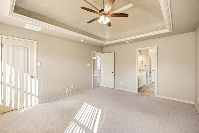 unfurnished bedroom with ornamental molding, a tray ceiling, ceiling fan, and light colored carpet