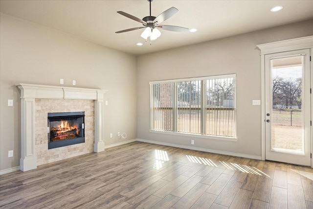 unfurnished living room with ceiling fan and a fireplace