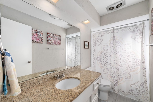 bathroom with a shower with curtain, vanity, and toilet