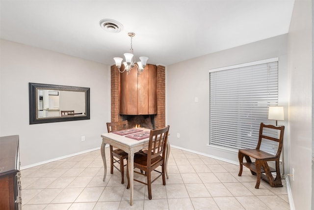 dining space with light tile patterned floors and an inviting chandelier