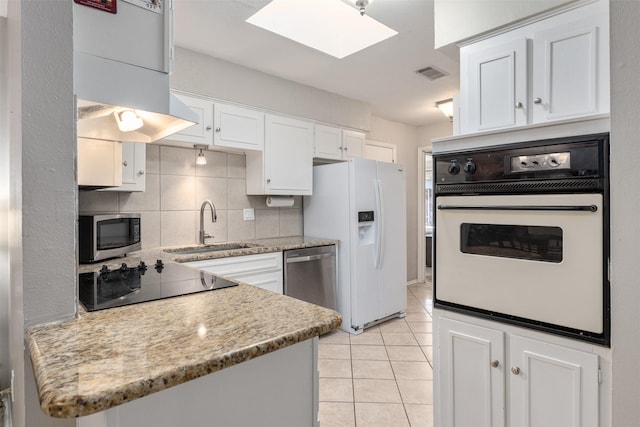 kitchen with sink, decorative backsplash, light stone countertops, appliances with stainless steel finishes, and white cabinetry