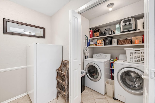 laundry area featuring light tile patterned floors and separate washer and dryer