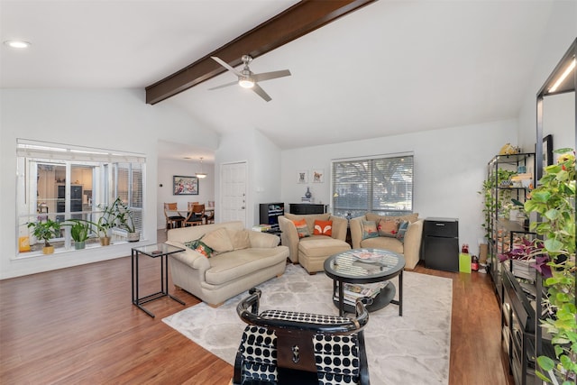 living room with hardwood / wood-style floors, vaulted ceiling with beams, and ceiling fan