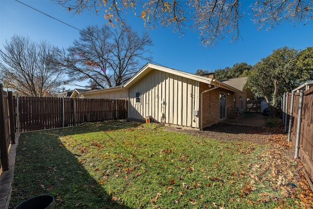 view of side of home with a yard